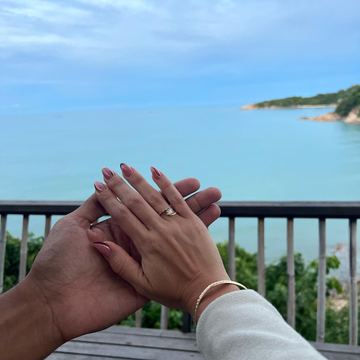 Two hands holding each other by the sea