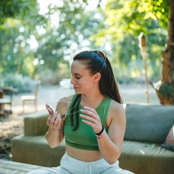 Julieta sitting cross-legged in a garden, smiling
